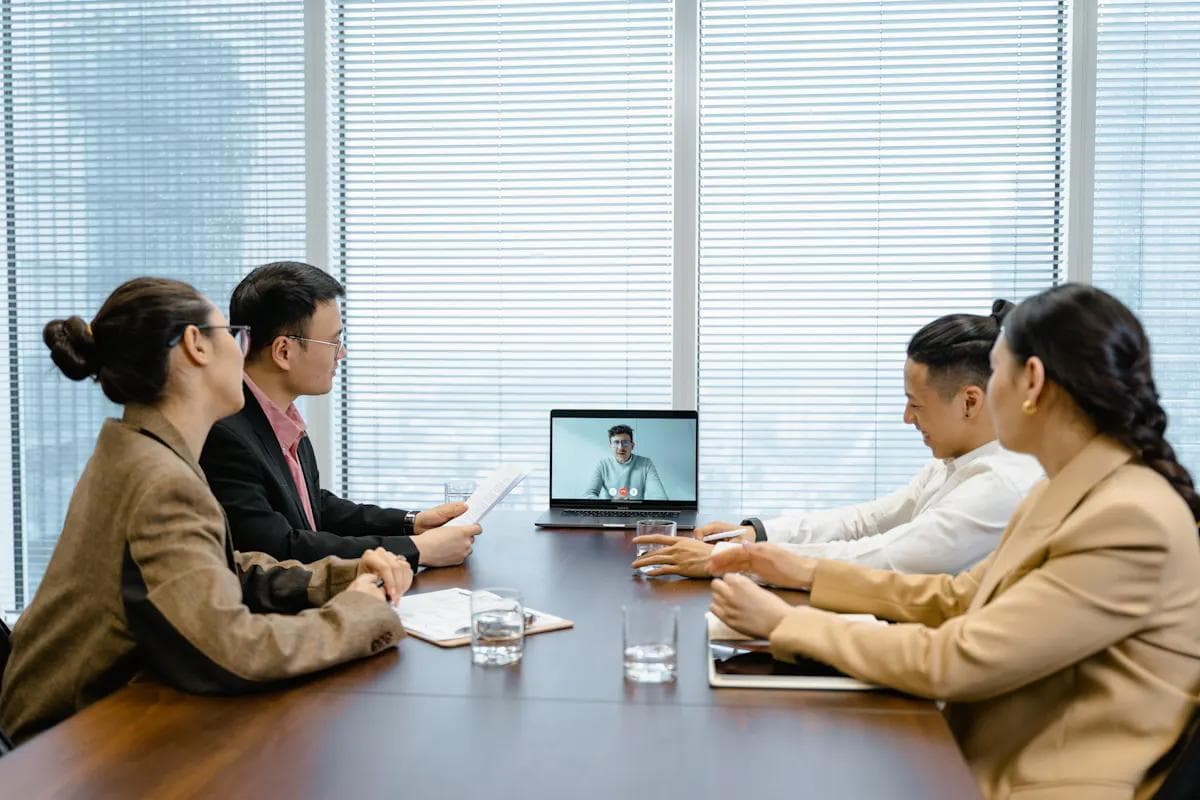 Business team in meeting with remote worker, showing enhanced customer experience in 2026.