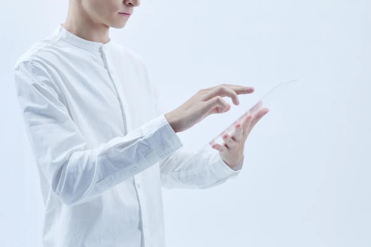 Person in white shirt using a transparent tablet, suggesting AI virtual assistant calls.