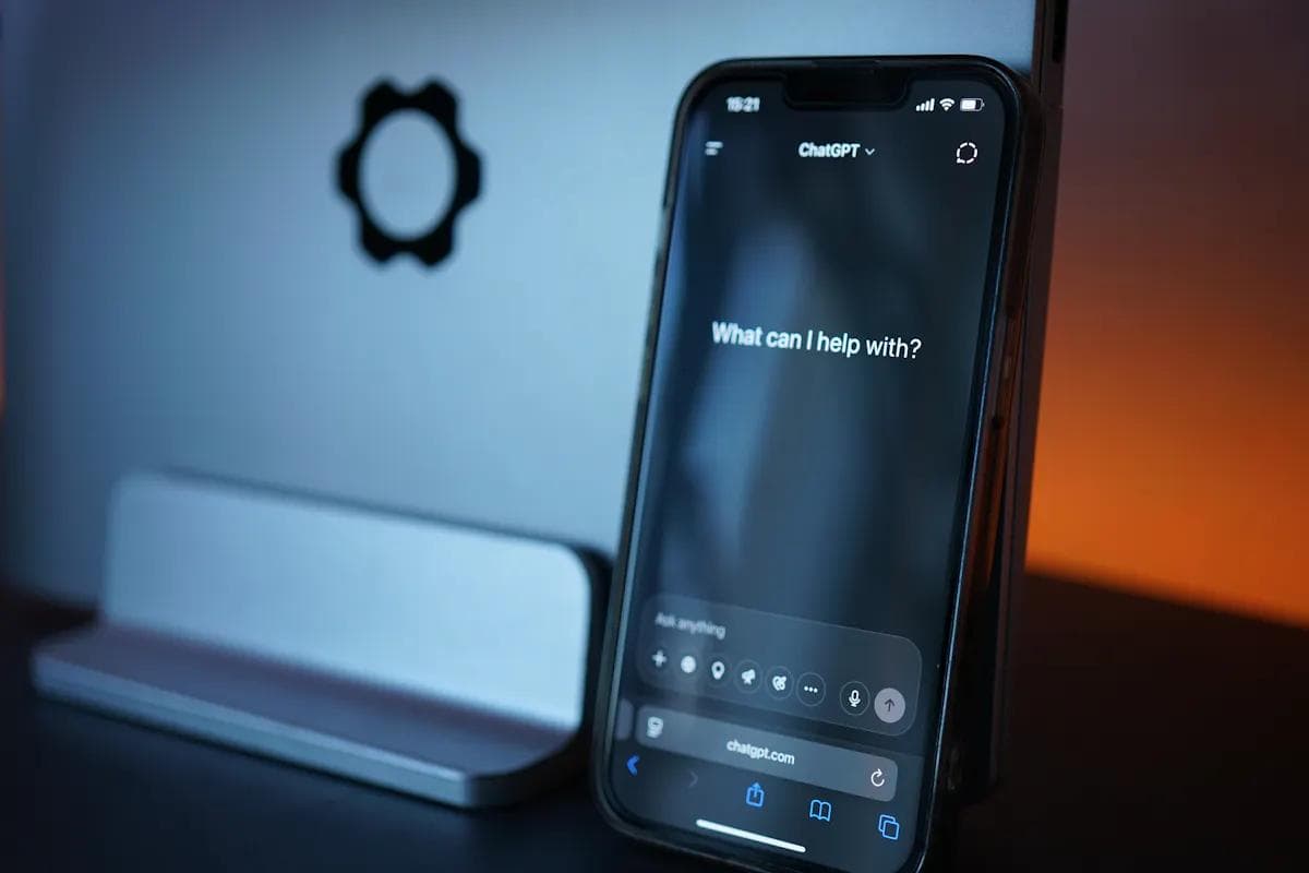 iPhone displaying a ChatGPT AI voice agent interface next to a laptop.